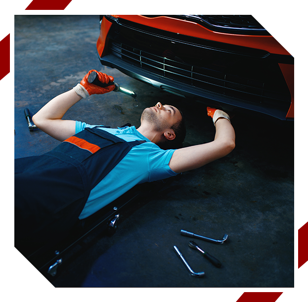 Mechanic inspecting a car from below